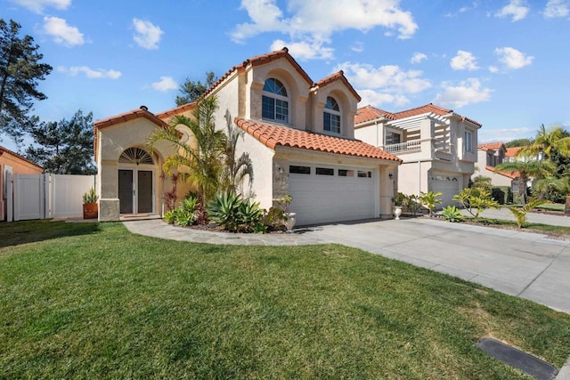 mediterranean / spanish-style home with concrete driveway, a tile roof, an attached garage, a front yard, and stucco siding