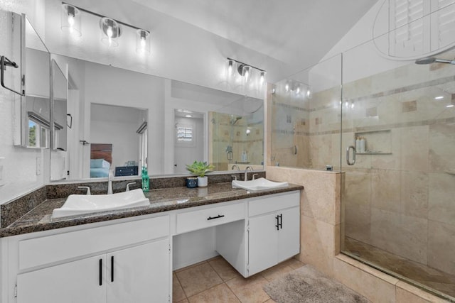 ensuite bathroom with tile patterned floors, ensuite bath, a sink, and a shower stall