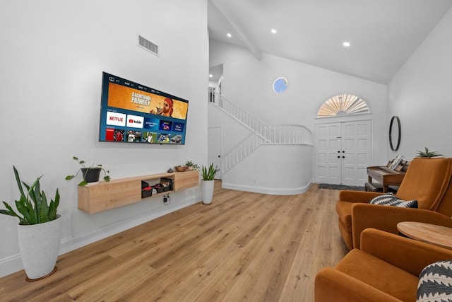 living area with visible vents, wood finished floors, stairs, high vaulted ceiling, and recessed lighting