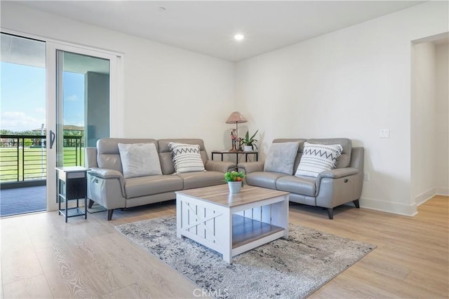 living area with recessed lighting, baseboards, and light wood-style floors