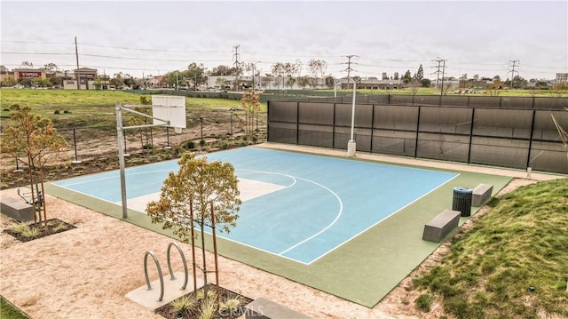 view of basketball court featuring basketball court and fence
