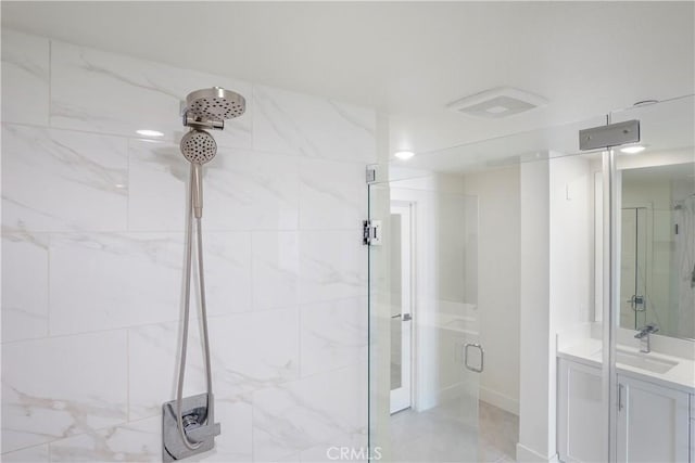 bathroom featuring a marble finish shower, baseboards, and vanity