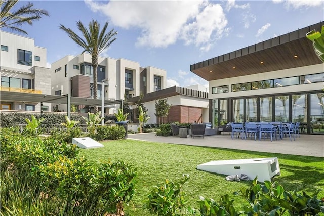 view of property's community with outdoor lounge area, a patio area, and a yard