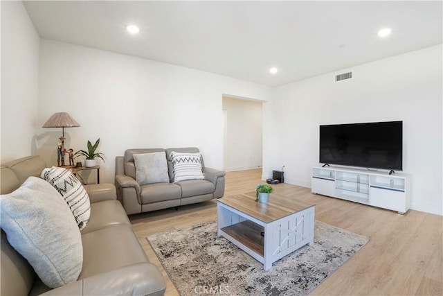living room with recessed lighting, baseboards, light wood finished floors, and visible vents