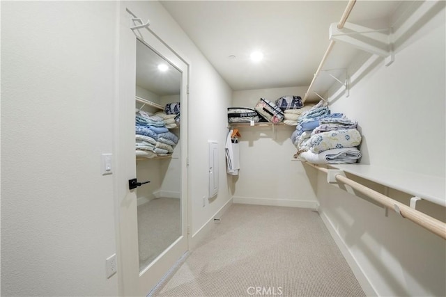 walk in closet featuring light colored carpet