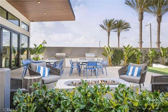 view of patio / terrace featuring an outdoor kitchen, an outdoor living space with a fire pit, and outdoor dining area