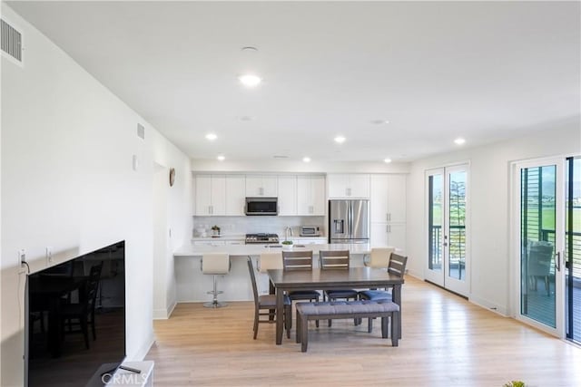 dining room with light wood-type flooring, recessed lighting, baseboards, and visible vents