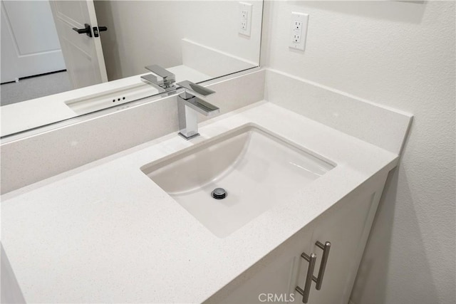 bathroom featuring a textured wall and vanity