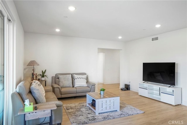 living room featuring recessed lighting, light wood finished floors, and visible vents