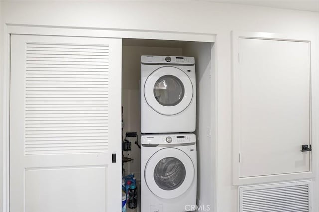 laundry area featuring stacked washer and clothes dryer and laundry area