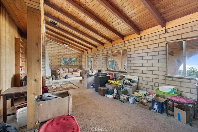 misc room featuring lofted ceiling with beams, brick wall, wooden ceiling, and carpet flooring