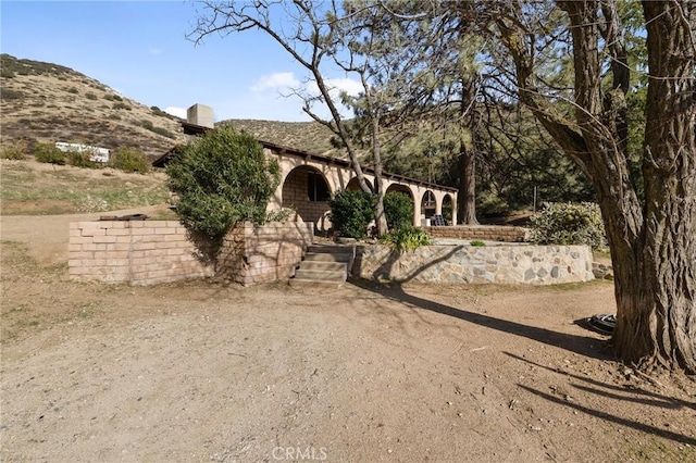 view of front of property with a chimney and a mountain view