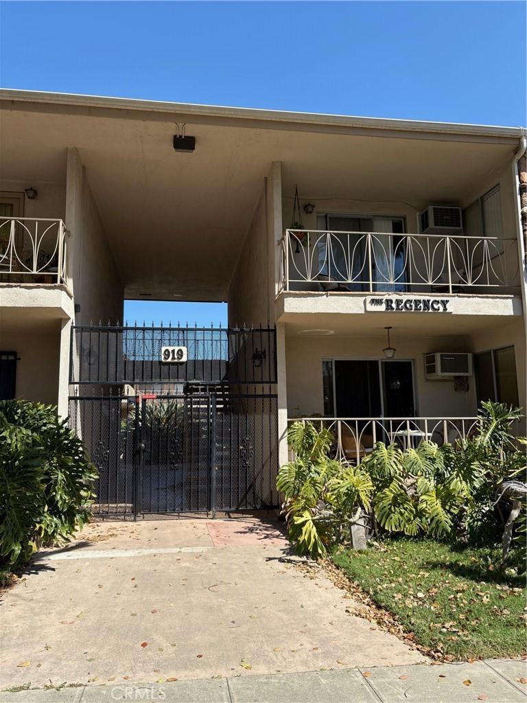 view of property with a wall unit AC and fence