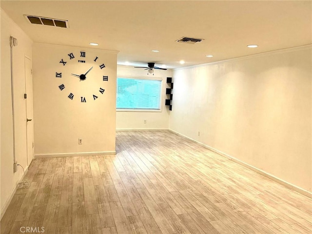 spare room with ceiling fan, light wood-style flooring, visible vents, and crown molding