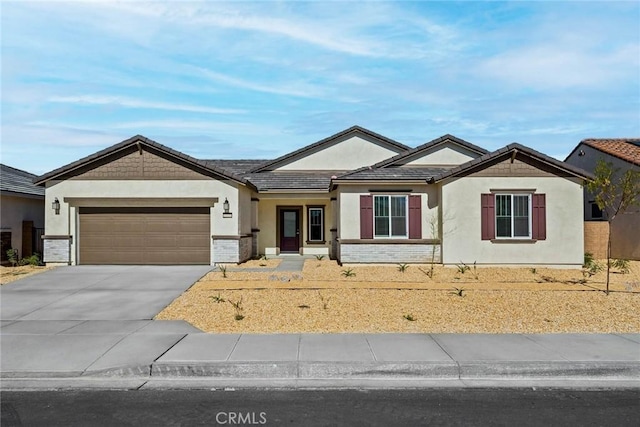 view of front of home featuring a tile roof, brick siding, stucco siding, concrete driveway, and an attached garage