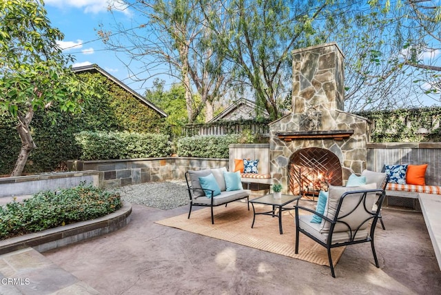 view of patio with an outdoor living space with a fireplace and fence