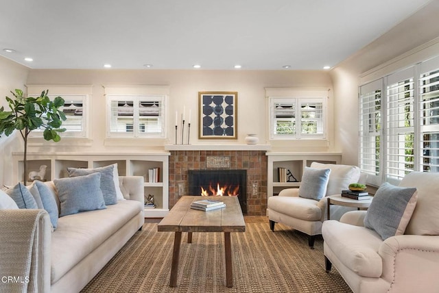 sitting room with a warm lit fireplace and recessed lighting