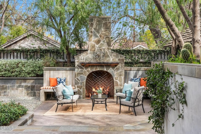 view of patio featuring an outdoor living space with a fireplace and fence