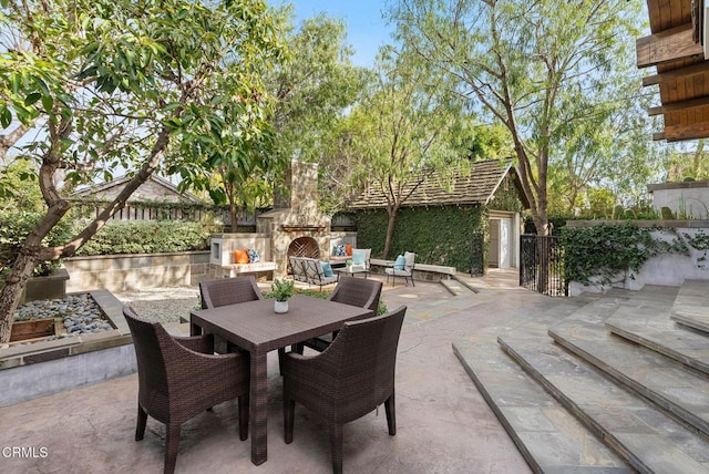 view of patio / terrace featuring an outdoor stone fireplace and outdoor dining space