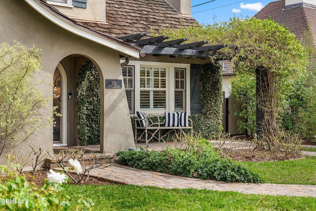 doorway to property with a porch and stucco siding