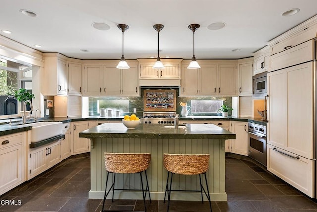 kitchen with built in appliances, a breakfast bar, a sink, stone finish flooring, and tasteful backsplash