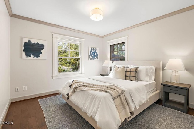 bedroom featuring dark wood-style floors, crown molding, and baseboards