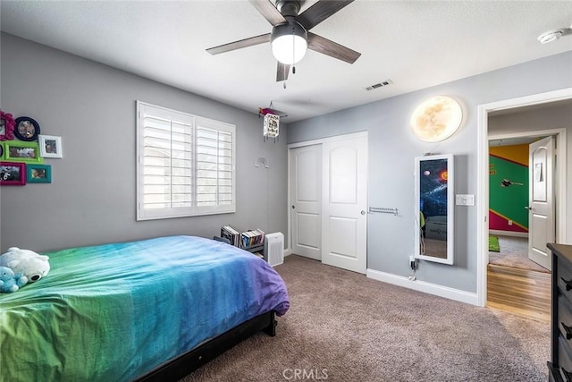 bedroom with baseboards, visible vents, a ceiling fan, carpet flooring, and a closet