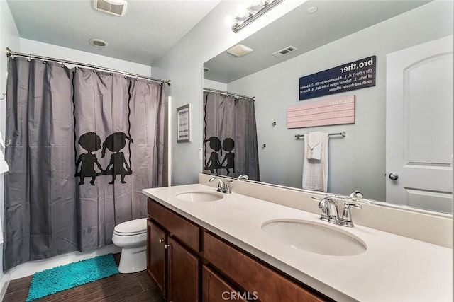 bathroom with toilet, visible vents, and a sink