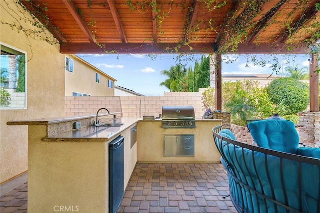 view of patio / terrace featuring a sink, exterior kitchen, a grill, and fence