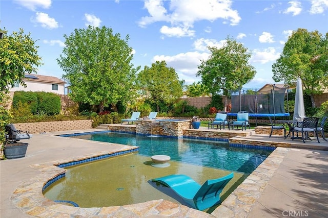 view of pool with a fenced in pool, a jacuzzi, a trampoline, fence, and a patio area