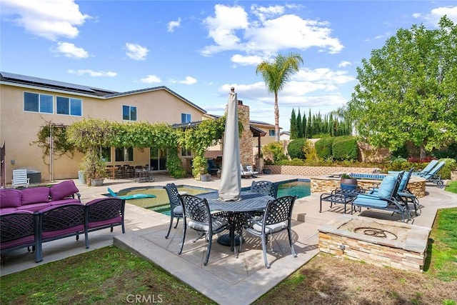 view of patio / terrace featuring outdoor dining area, an outdoor living space with a fire pit, an outdoor pool, and an in ground hot tub