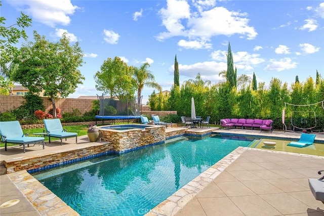 view of swimming pool with an in ground hot tub, fence, a fenced in pool, a trampoline, and a patio area