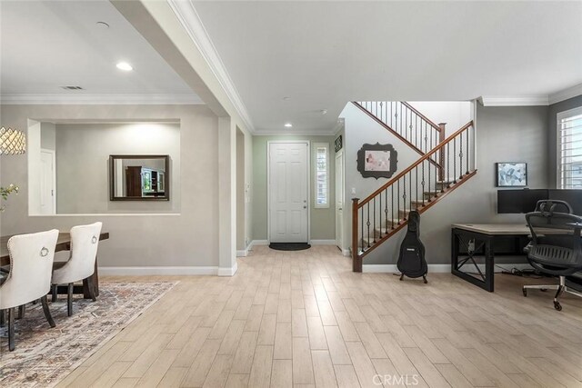 entryway featuring stairs, ornamental molding, baseboards, and wood finished floors