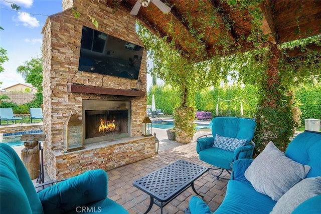 view of patio / terrace featuring an outdoor living space with a fireplace, fence, and a fenced in pool