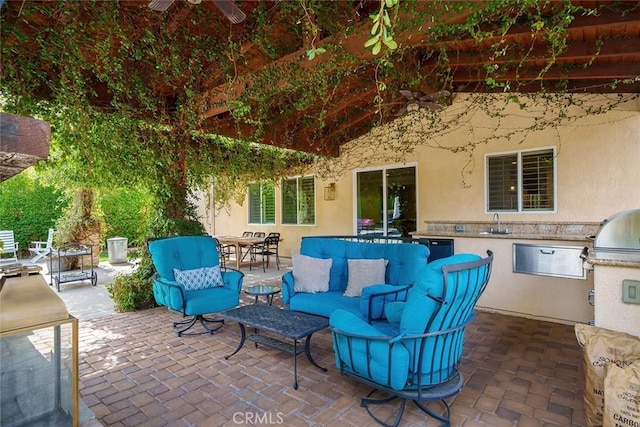 view of patio with an outdoor hangout area, outdoor dining space, a sink, and exterior kitchen