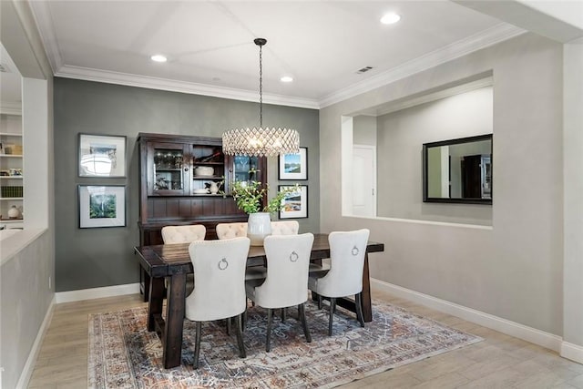 dining area featuring a chandelier, recessed lighting, wood finished floors, baseboards, and ornamental molding