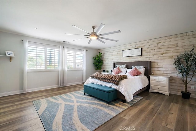 bedroom with ceiling fan, baseboards, and wood finished floors