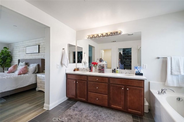 full bath with double vanity, ensuite bath, a sink, and a washtub