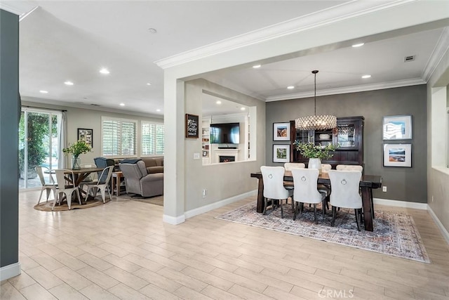 dining area with light wood-style floors, baseboards, crown molding, and recessed lighting