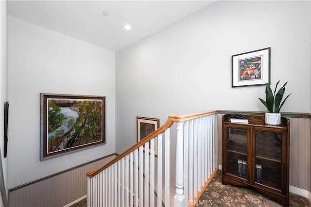 staircase featuring a wainscoted wall and recessed lighting