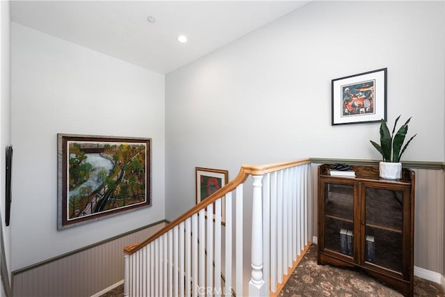stairway with a wainscoted wall and recessed lighting
