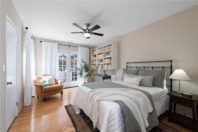 bedroom with access to exterior, french doors, light wood-style floors, and a ceiling fan