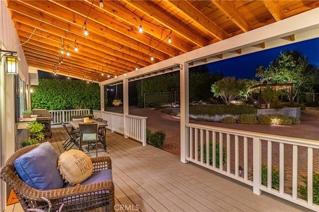 deck at twilight with outdoor dining space