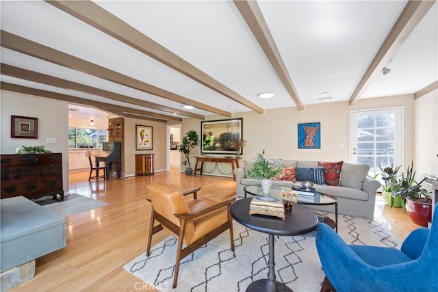 living area featuring light wood-style flooring and beam ceiling