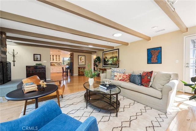 living room featuring beamed ceiling and wood finished floors