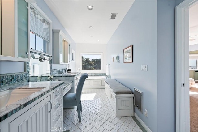 home office featuring light tile patterned floors, recessed lighting, visible vents, a sink, and baseboards