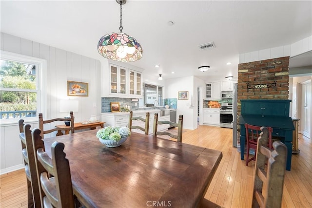 dining space featuring light wood finished floors and visible vents