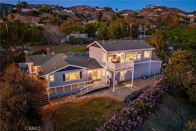 back of house featuring a patio area, a mountain view, and a balcony