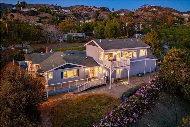 back of house with a patio, a mountain view, and a balcony