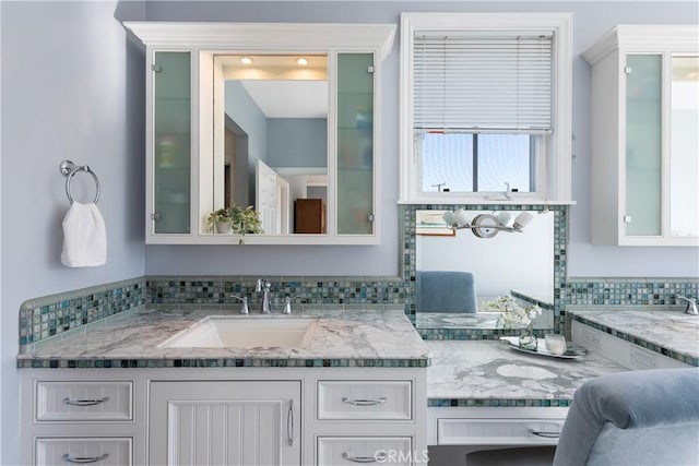 bathroom featuring vanity and decorative backsplash